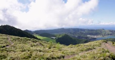Sete Cidades 'teki bir kraterde güzel bir volkanik göl. Göl, Azores 'in Sao Miguel adasında açık güneşli bir günde ağaçlar ve okyanuslarla çevrilidir. İzleme görüntüsü.