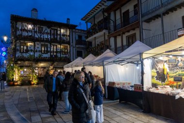 Candeleda, Avila, İspanya, 10 Aralık 2025: Çadırları kurulmuş bir binanın önünde bir grup insan duruyor. Çadırlar beyaz ve etraflarında bir sürü insan var..