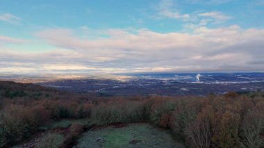 Drone arka planında büyük bir dağ olan güzel bir şehrin üzerinde uçuyor. Gökyüzü açık ve İspanya, Orense 'de güneş parlıyor..