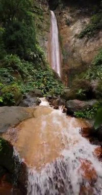 Ribeira Quente yemyeşil bir ormanda büyük bir şelale. Su, Azores Sao Miguel adasındaki bir uçurumdan aşağı akıyor. Statik çekim.