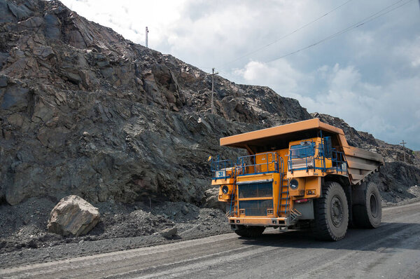 open cast dump truck drives alone industrial area of iron ore quarry