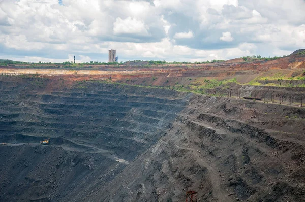 深い採石場で鉄鉱石を採掘する大型ダンプトラック 掘削機 掘削機 機関車 — ストック写真