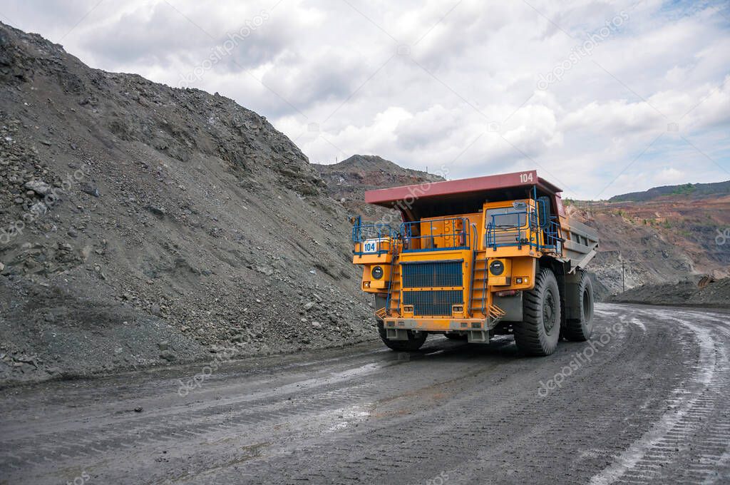 open cast dump truck drives alone industrial area of iron ore quarry