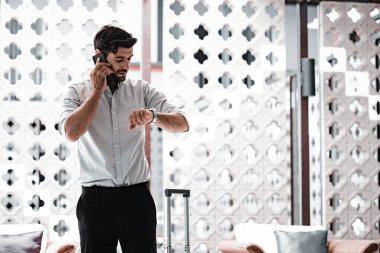 Handsome young bearded businessman with mobile phone