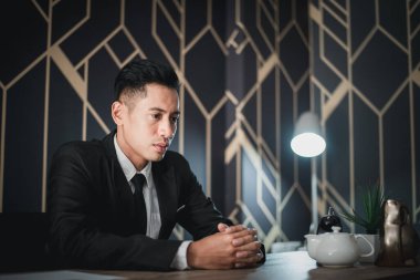 Masada oturan yakışıklı genç iş adamı.