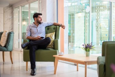 Handsome young bearded businessman with mobile phone