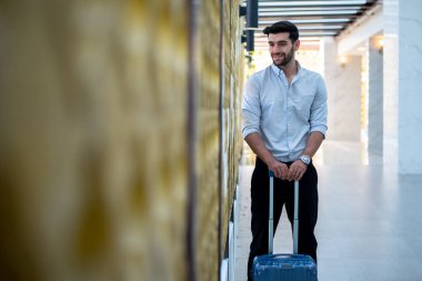Handsome young bearded businessman with suitcase 