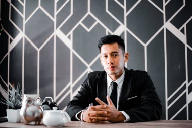 Masada oturan yakışıklı genç iş adamı.