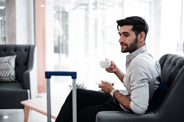 Handsome young bearded businessman with coffee mug