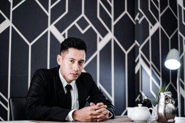 Masada oturan yakışıklı genç iş adamı.