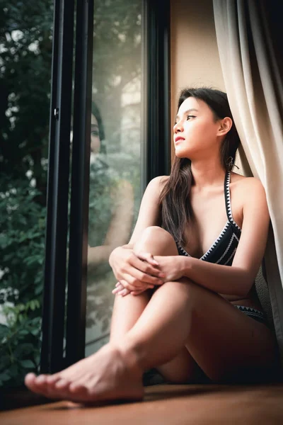Çamaşırlı Güzel Asyalı Kadın Pencere Eşiğinde Oturuyor Pencereden Dışarı Bakıyor — Stok fotoğraf