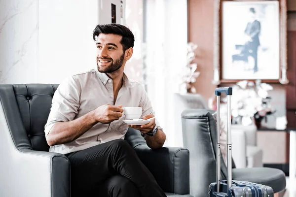 Handsome young bearded businessman with coffee mug