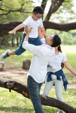 Parkta poz veren Asyalı bir aile.