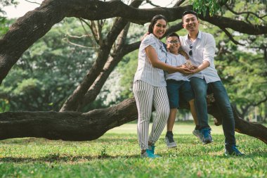 Parkta poz veren Asyalı bir aile.