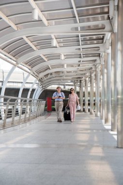 Tren istasyonunda yürüyen Asyalı çift.