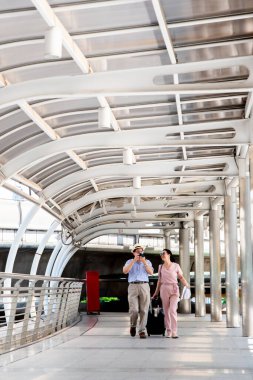 Tren istasyonunda yürüyen Asyalı çift.