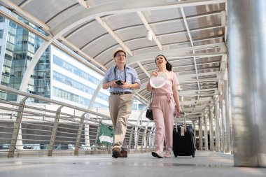 Tren istasyonunda yürüyen Asyalı çift.