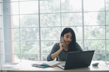 Genç ve güzel bir bayan girişimci ofis telefonundan konuşuyor.