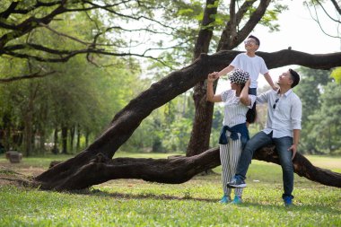 Parkta poz veren Asyalı bir aile.