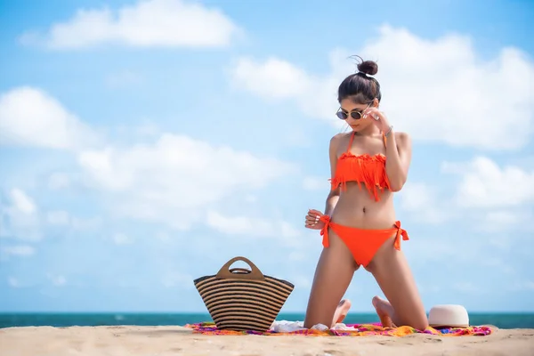 Asian sexy woman in orange bikini posing