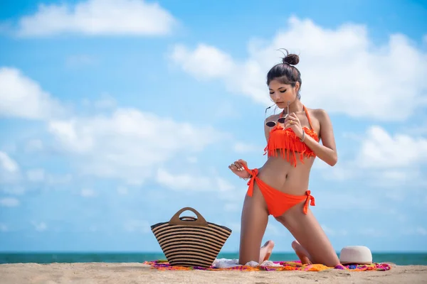 Asian sexy woman in orange bikini posing