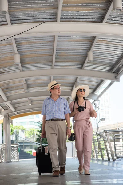 Asian couple walking on train station