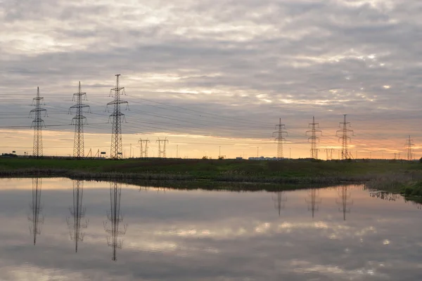 De lijn van de macht op het platteland bij zonsondergang. — Stockfoto