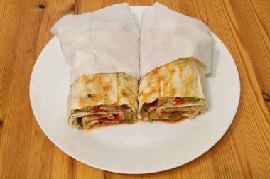 Beyaz tabakta ince buğday soslu ev yapımı shawarma..
