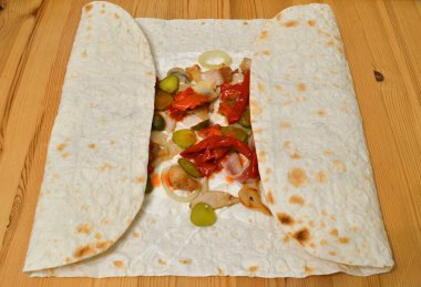 İnce buğday ekmeğinde ev yapımı shawarma pişirme aşamasında..