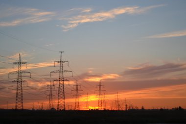 Gün batımında elektrik iletim hatları.