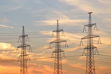 Gün batımında elektrik iletim hatları.