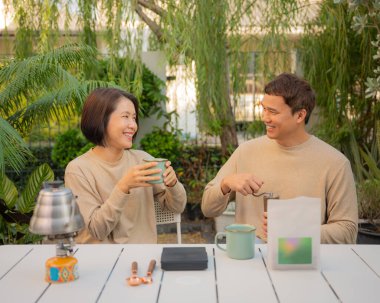 Çift mutlu bir şekilde bahçede birlikte kahve yapıyor..