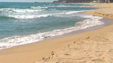 Beyaz dalgalar ve kumlu plaj denize sıfır