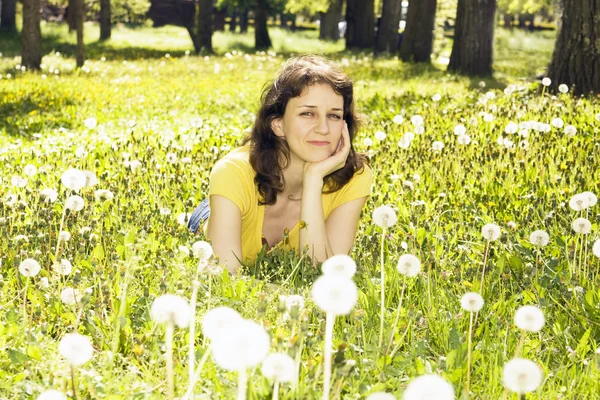 Jeune femme avec des pissenlits blancs — Photo