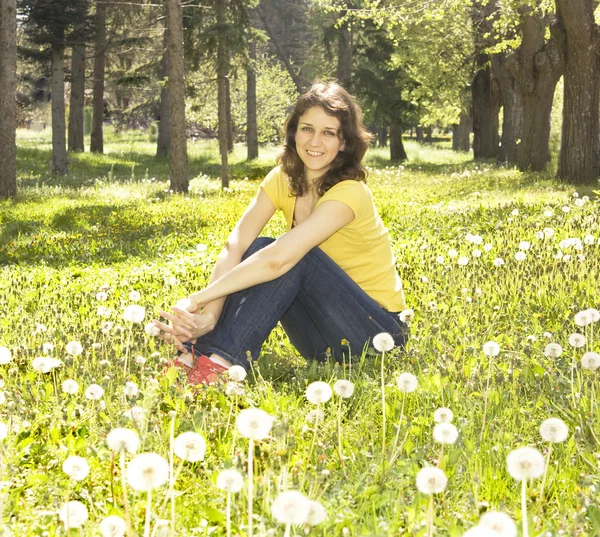 Jonge vrouw met witte paardebloemen — Stockfoto