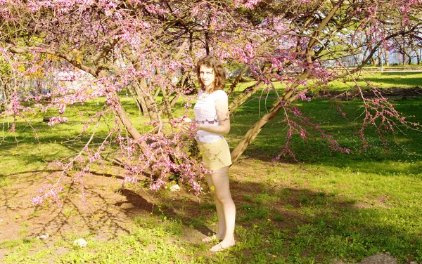 Jonge vrouw met roze boom — Stockfoto