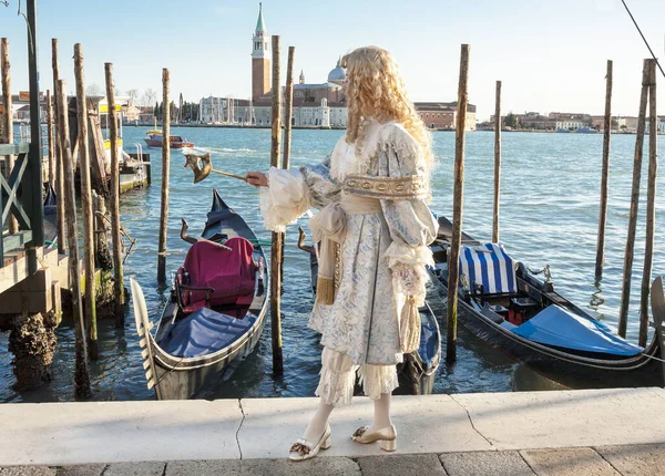 VENISE, ITALIE - 20 FÉVRIER 2020 : Homme en costume de carnaval et masque sur le carnaval, les gondoles et le monastère Saint-Georges. — Photo