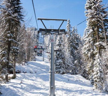 Bulgaristan 'ın Pamporovo kentindeki Rhodopes dağlarındaki Pamporovo tatil beldesinde teleferik kayakçıları.