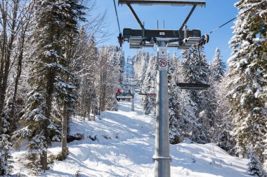 Bulgaristan 'ın Pamporovo kentindeki Rhodopes dağlarındaki Pamporovo tatil beldesinde teleferik kayakçıları.
