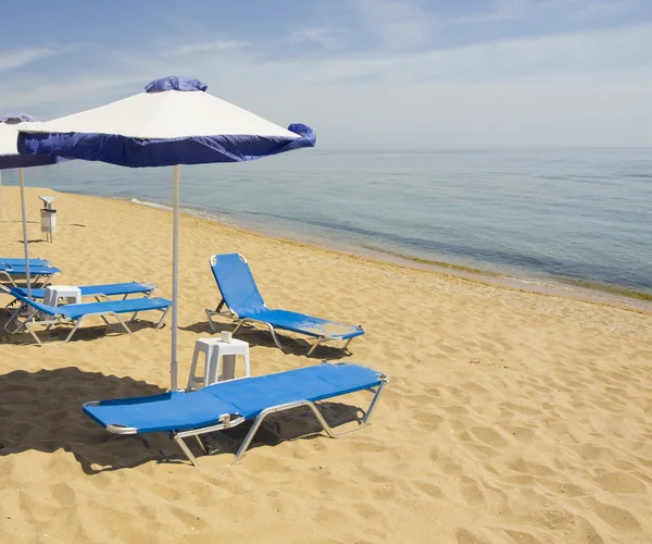 Blue-white beach umbrellas and chaise lounges — Stock Photo, Image