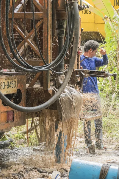 Hombre perforando un nuevo agua — Foto de Stock