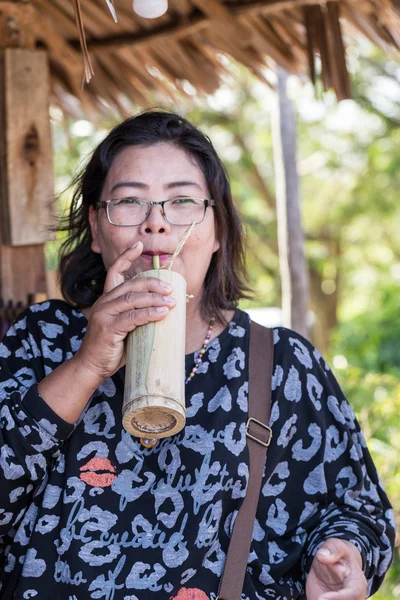 Kvinna hålla bambu röret för dricksvatten — Stockfoto