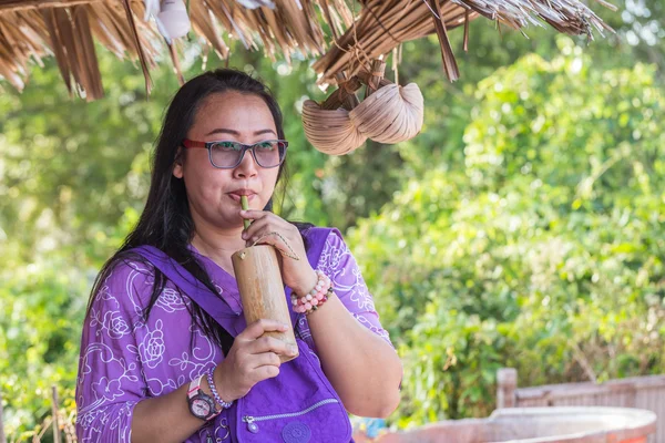 Donna tenere tubo di bambù per acqua potabile — Foto Stock