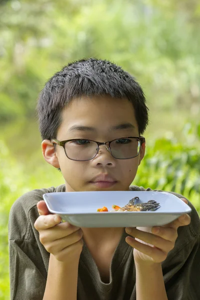 Ragazzo pensieroso guarda osso di pesce mangiato chiaramente sul piatto — Foto Stock
