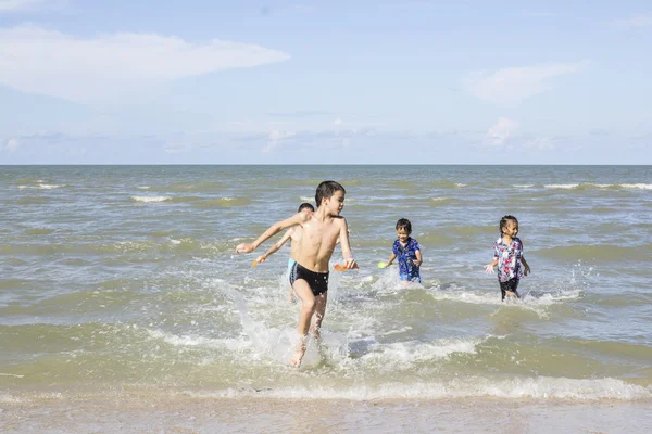 Niños felices jugando en el océano — Foto de Stock