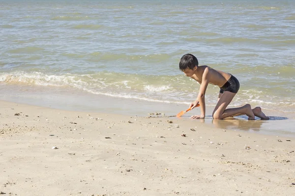 ビーチで砂の中のタイの少年プレイ — ストック写真