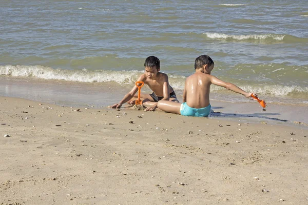 Thailändsk pojke spela i sanden på stranden — Stockfoto