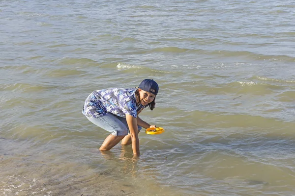 Woman seeking shells in the shallow water during low tide — Stock Photo, Image