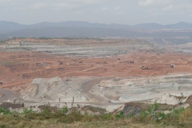 Açık bir çukurda kömür madenciliği. Dağlar ve ağaçlarla kaplı manzara.