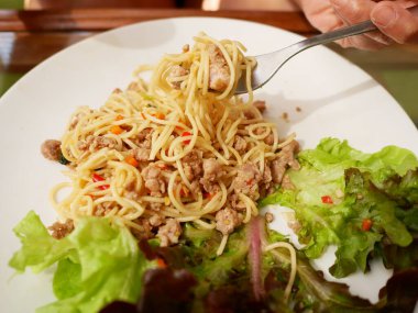 Kıymalı spagetti ve beyaz tabakta sebze, Tayland yemeği.